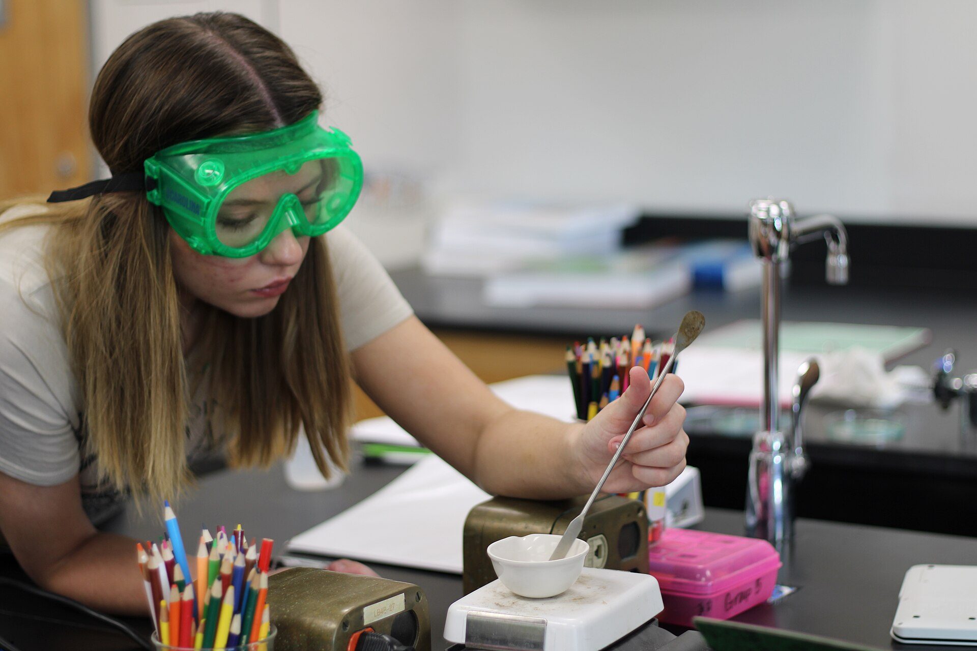 A student in safety goggles running a chemistry experiment
